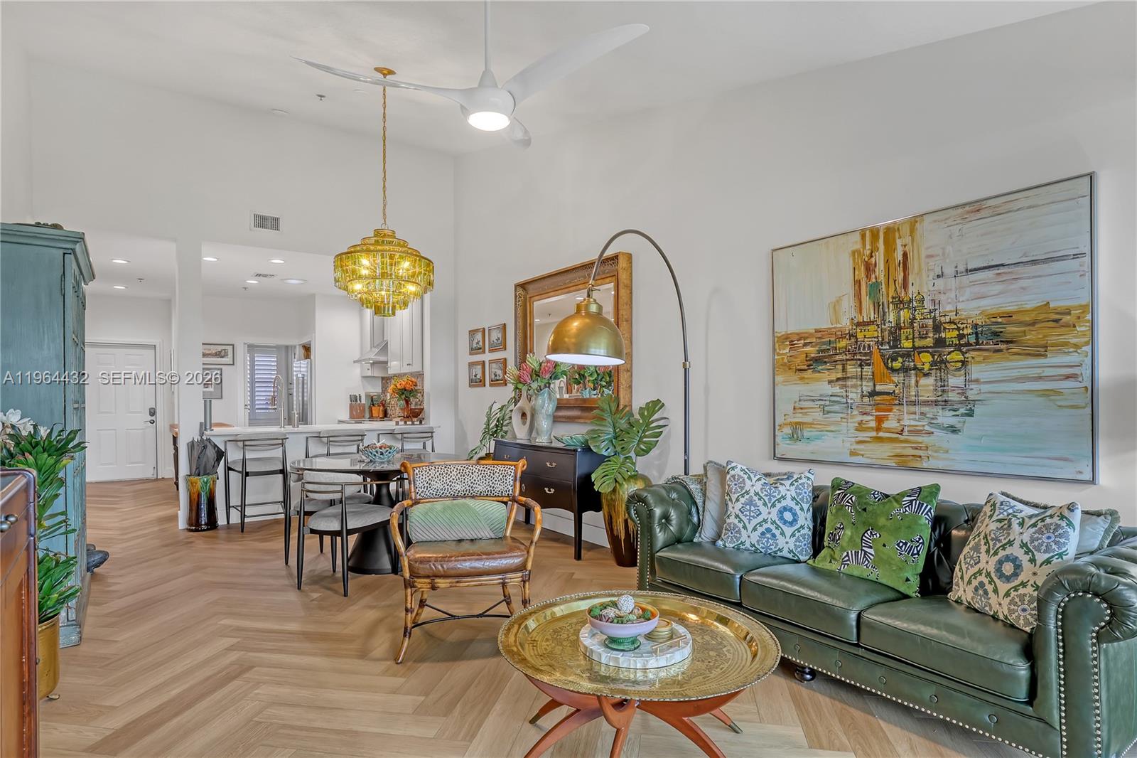 6062 Southeast Landing Way, Unit 10 Stuart, FL 34997 - Photo 20 of 37 a living room with fireplace furniture and a chandelier