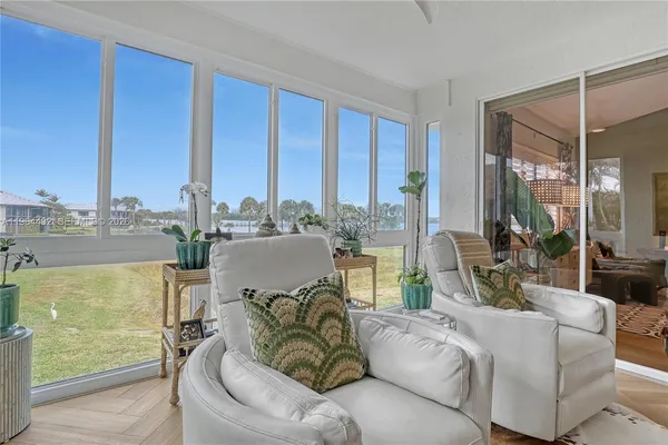 a living room with furniture and floor to ceiling windows