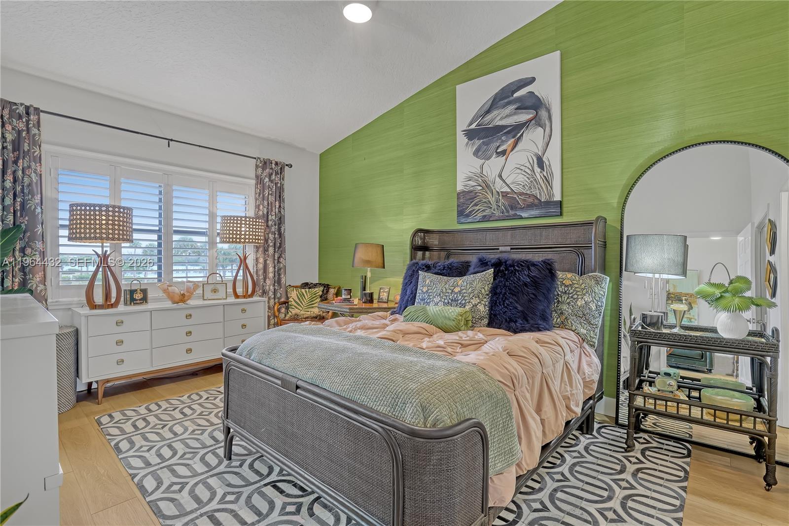 6062 Southeast Landing Way, Unit 10 Stuart, FL 34997 - Photo 26 of 37 a bedroom with a bed and wooden floor