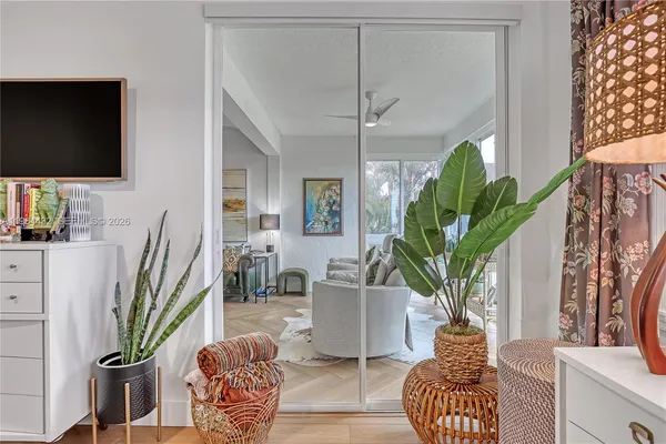 a living room with furniture a potted plant and a flat screen tv