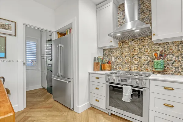 a kitchen with stainless steel appliances granite countertop a refrigerator and a stove