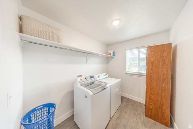 4765 Breezy Patch Road Eagle Mountain, UT 84005 - Photo 12 of 25 Dedicated laundry area featuring white walls, a single window with horizontal blinds, and wood-finish flooring