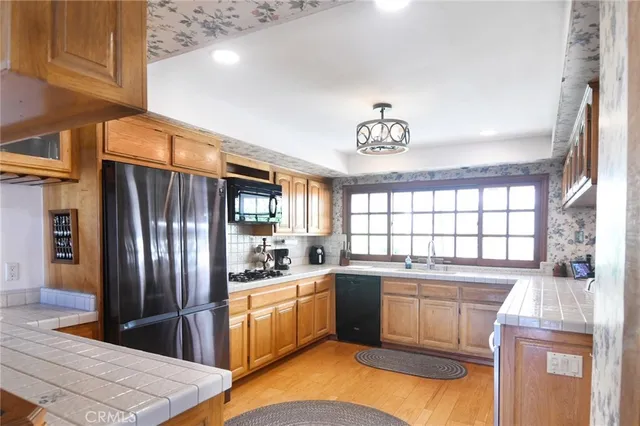 a kitchen that has a sink stainless steel appliances a window and a counter top space