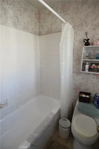 a white toilet sitting next to a bath tub