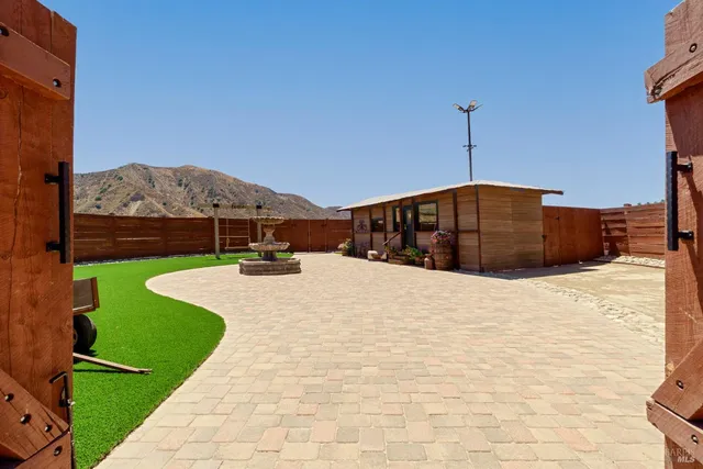 a view of an swimming pool with a lawn chairs under an umbrella