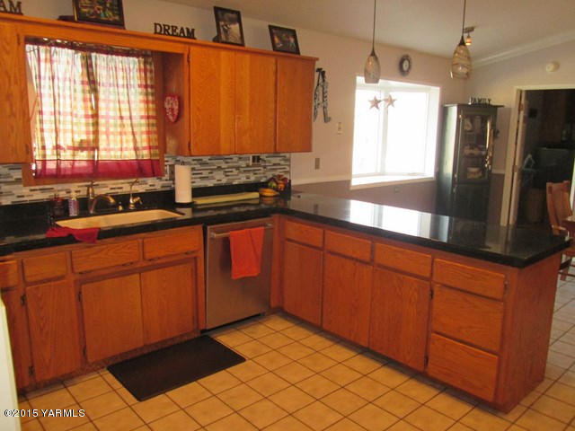 882 Maple Grove Road Sunnyside, WA 98944 - Photo 22 of 42 a kitchen with stainless steel appliances granite countertop a refrigerator and a sink