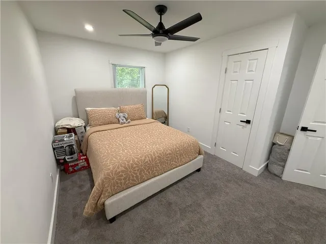 a bedroom with a bed and a ceiling fan