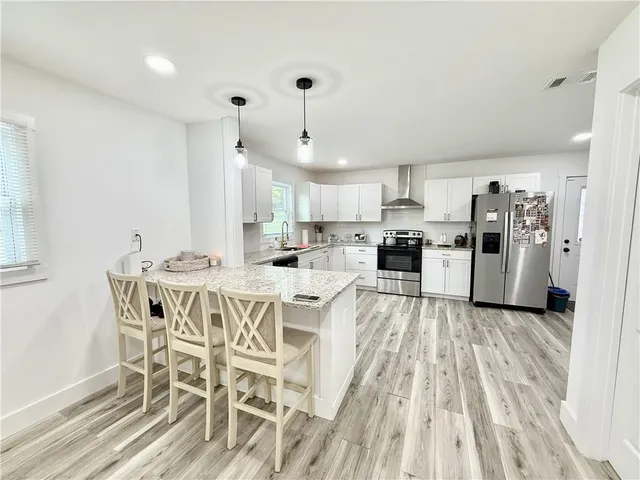 a view of a kitchen with furniture and wooden floor