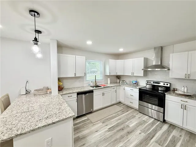 a kitchen with stainless steel appliances granite countertop a sink stove and refrigerator