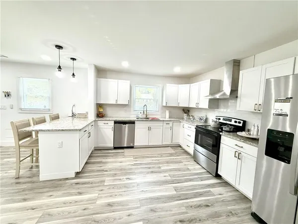 a large kitchen with cabinets stainless steel appliances a sink and a window