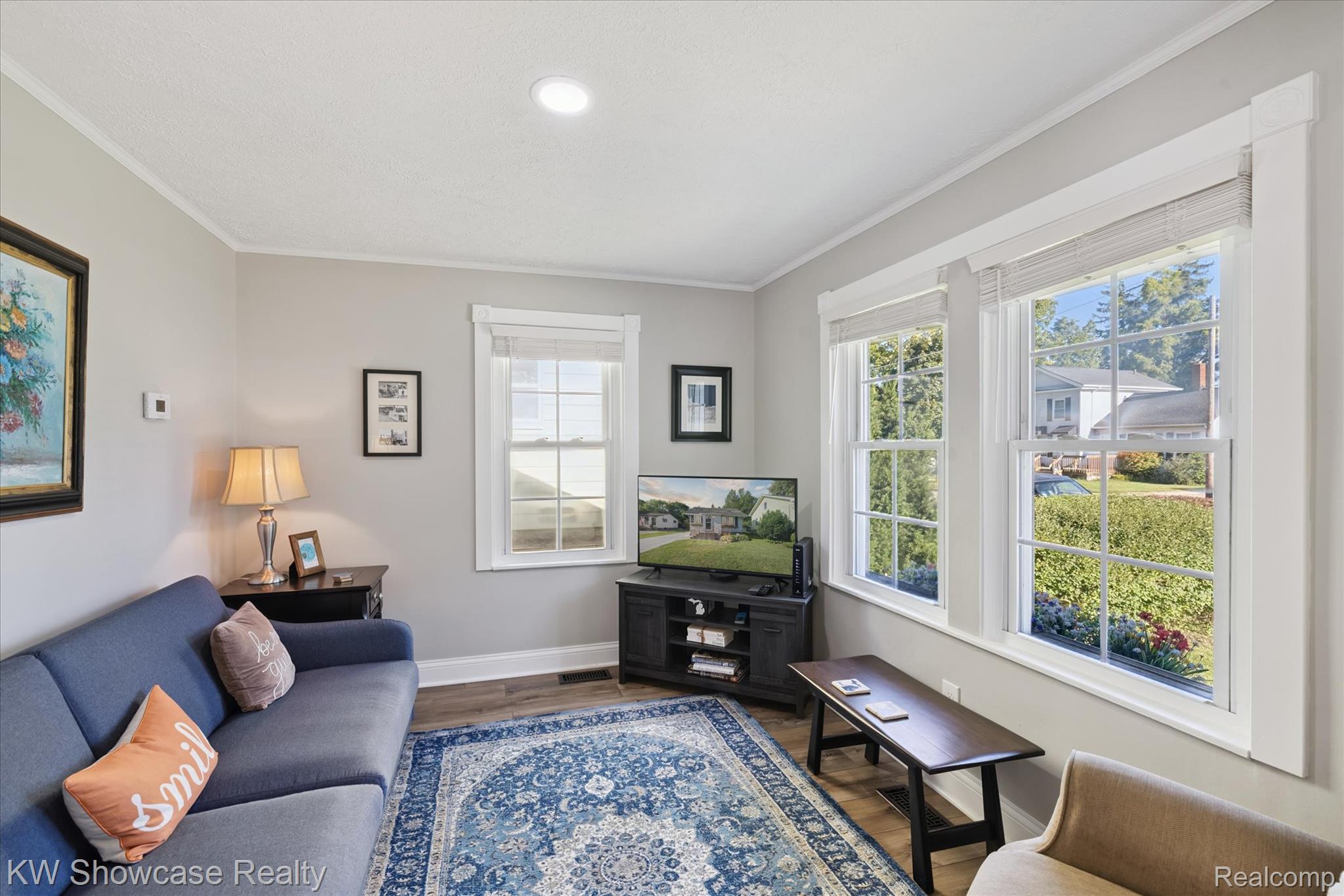 603 West Clinton Street Howell, MI 48843 - Photo 14 of 25 Living room with wood finished floors, crown molding, and healthy amount of natural light