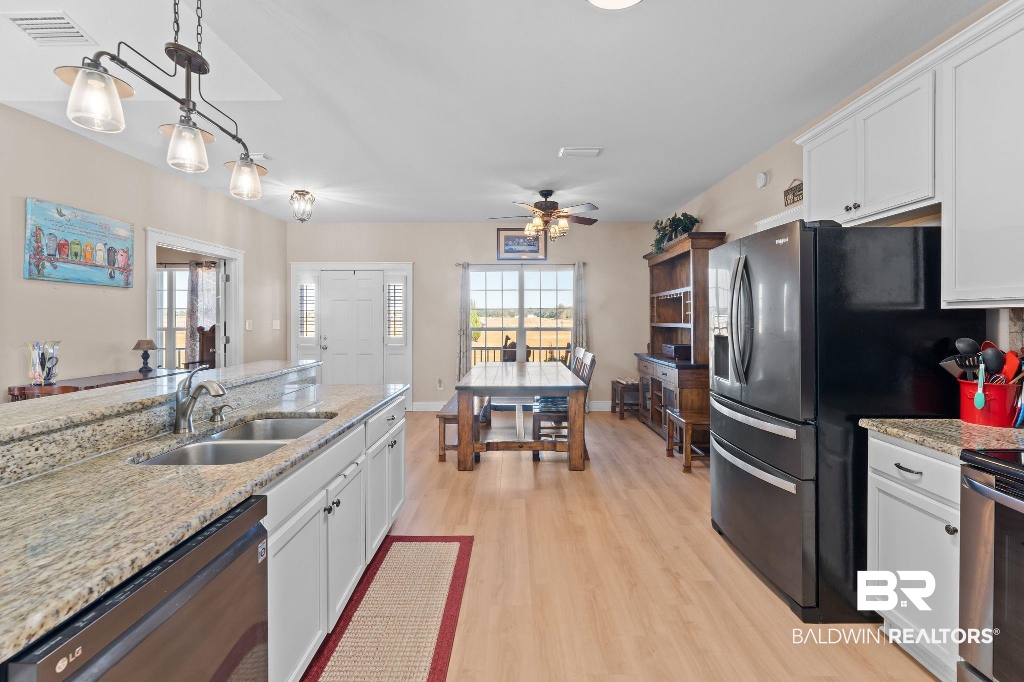 28980 Comstock Road Elberta, AL 36530 - Photo 9 of 38 Kitchen featuring white cabinetry, light stone counters, pendant lighting, and stainless steel appliances