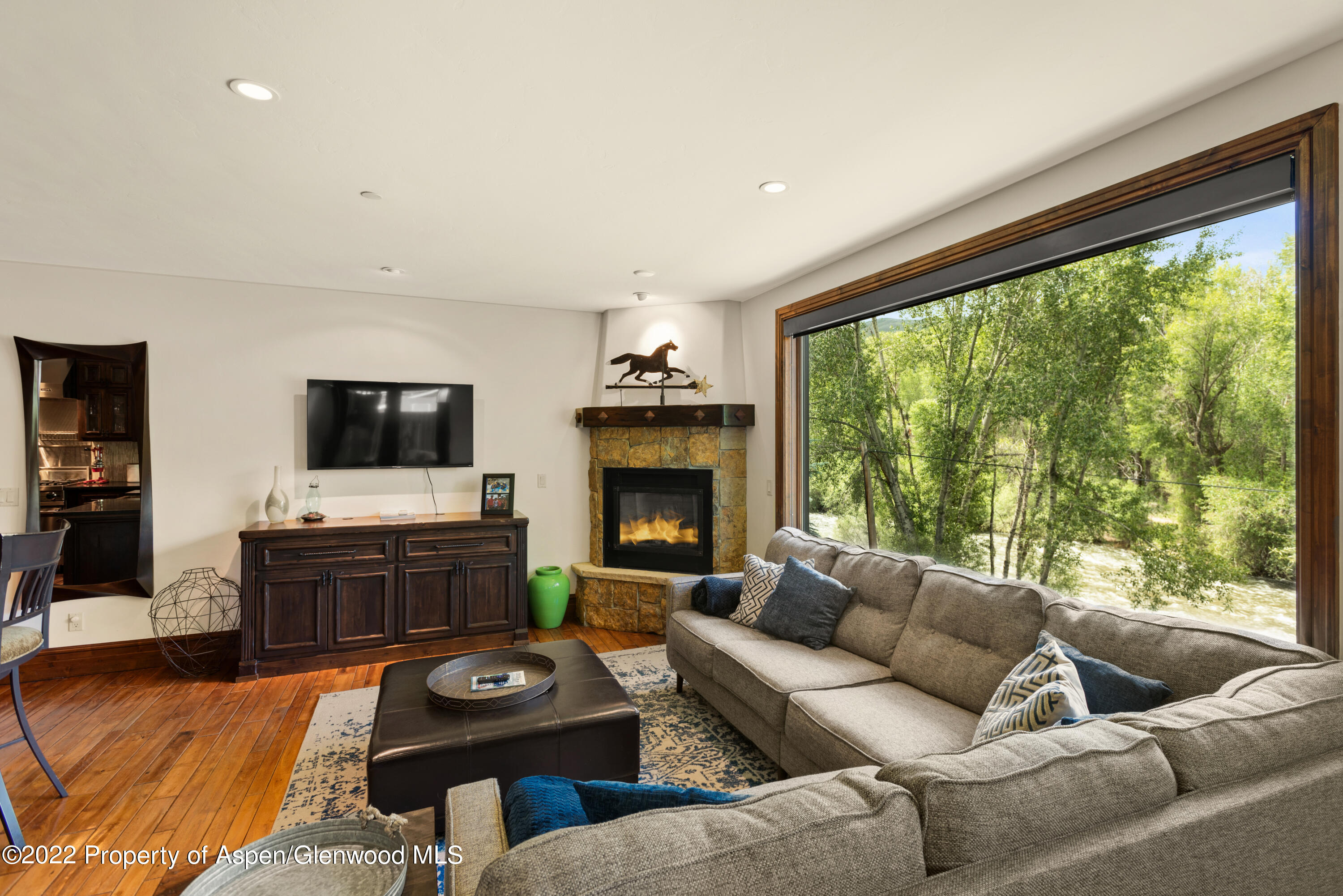 23272 2 Rivers Road, Unit 201 Basalt, CO 81621 - Photo 13 of 25 a living room with furniture a flat screen tv and a floor to ceiling window