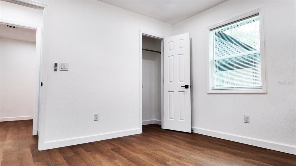 2607 Northeast 140th Street Citra, FL 32113 - Photo 20 of 36 an empty room with wooden floor and windows
