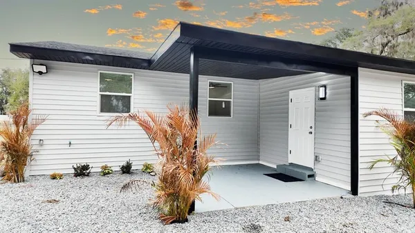 a view of a house with a door and wooden bench