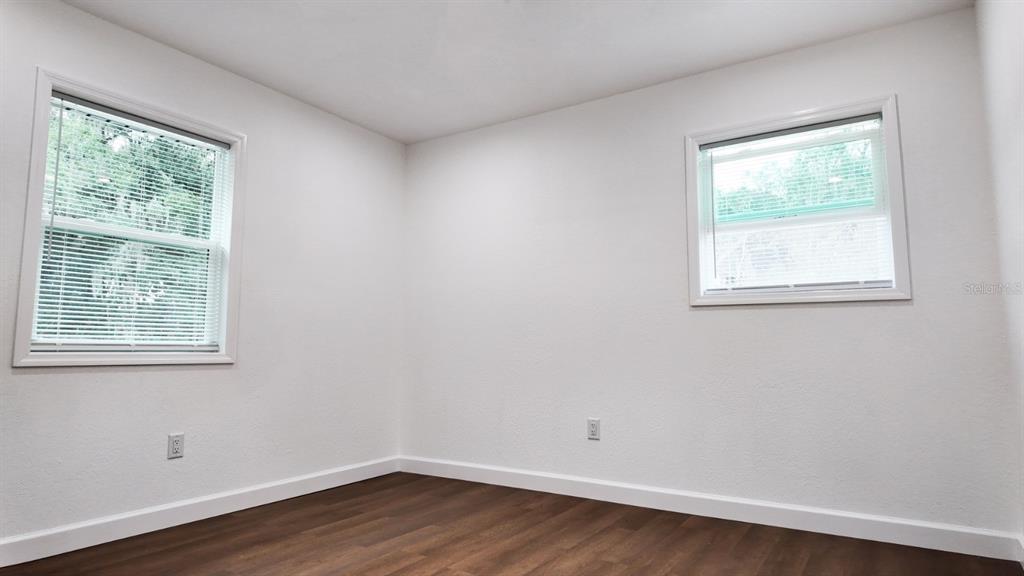 2607 Northeast 140th Street Citra, FL 32113 - Photo 21 of 36 an empty room with wooden floor and windows