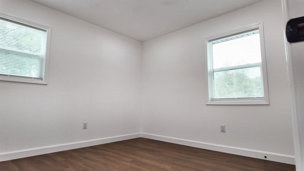 2607 Northeast 140th Street Citra, FL 32113 - Photo 22 of 36 an empty room with wooden floor and windows