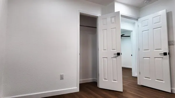 a view of an empty room with wooden floor