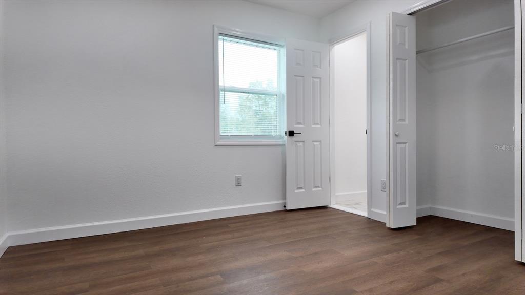 2607 Northeast 140th Street Citra, FL 32113 - Photo 27 of 36 a view of an empty room with wooden floor and a window