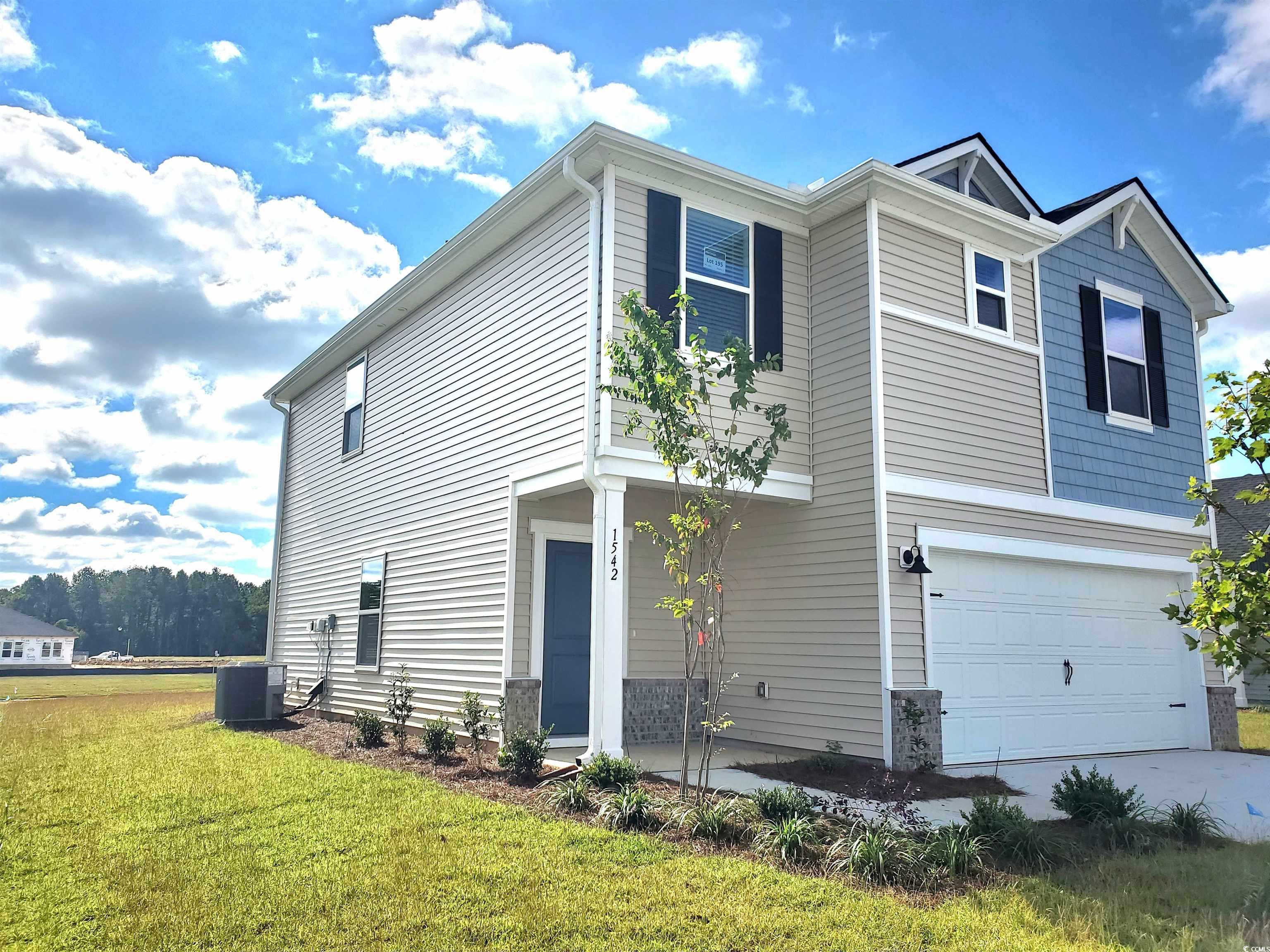 View of front of home with a garage and a front lawn