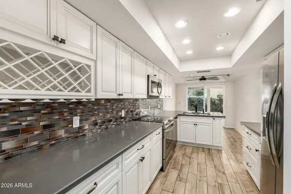 a kitchen with stainless steel appliances granite countertop a sink stove and refrigerator