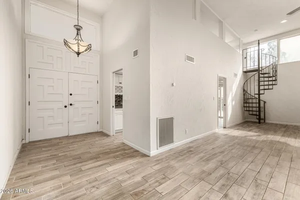 a view of empty room with wooden floor and ceiling fan