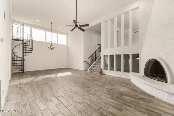 a view of a livingroom with wooden floor and staircase