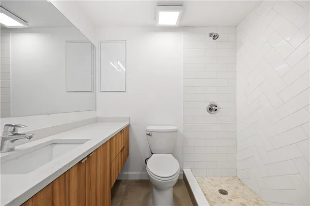 a bathroom with a sink a toilet and shower