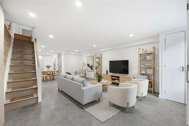a living room with furniture and a kitchen counter space