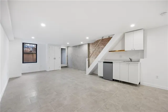 an empty room with a kitchen and a sink