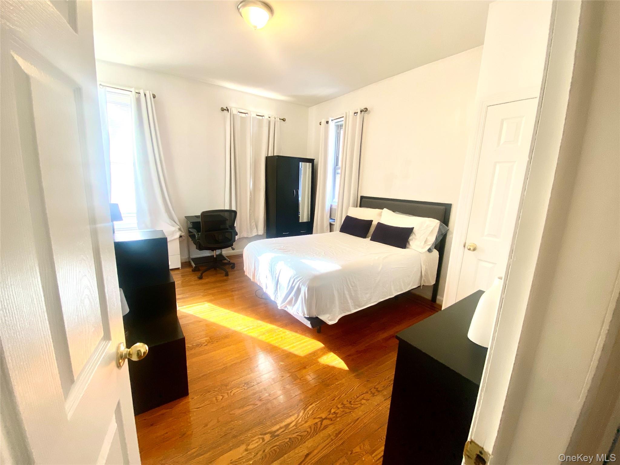 92-02 37th Avenue, Unit 2C Queens, NY 11372 - Photo 2 of 7 Bedroom featuring wood finished floors and an office area