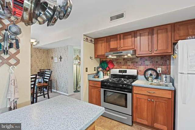 a kitchen with stainless steel appliances granite countertop a stove a sink and a refrigerator