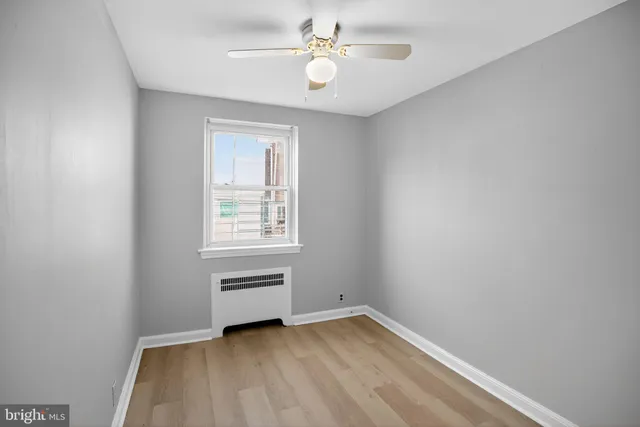 an empty room with a window and ceiling fan