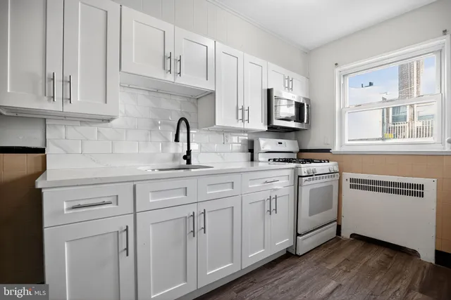 a kitchen with stainless steel appliances granite countertop a sink a stove a microwave and cabinets