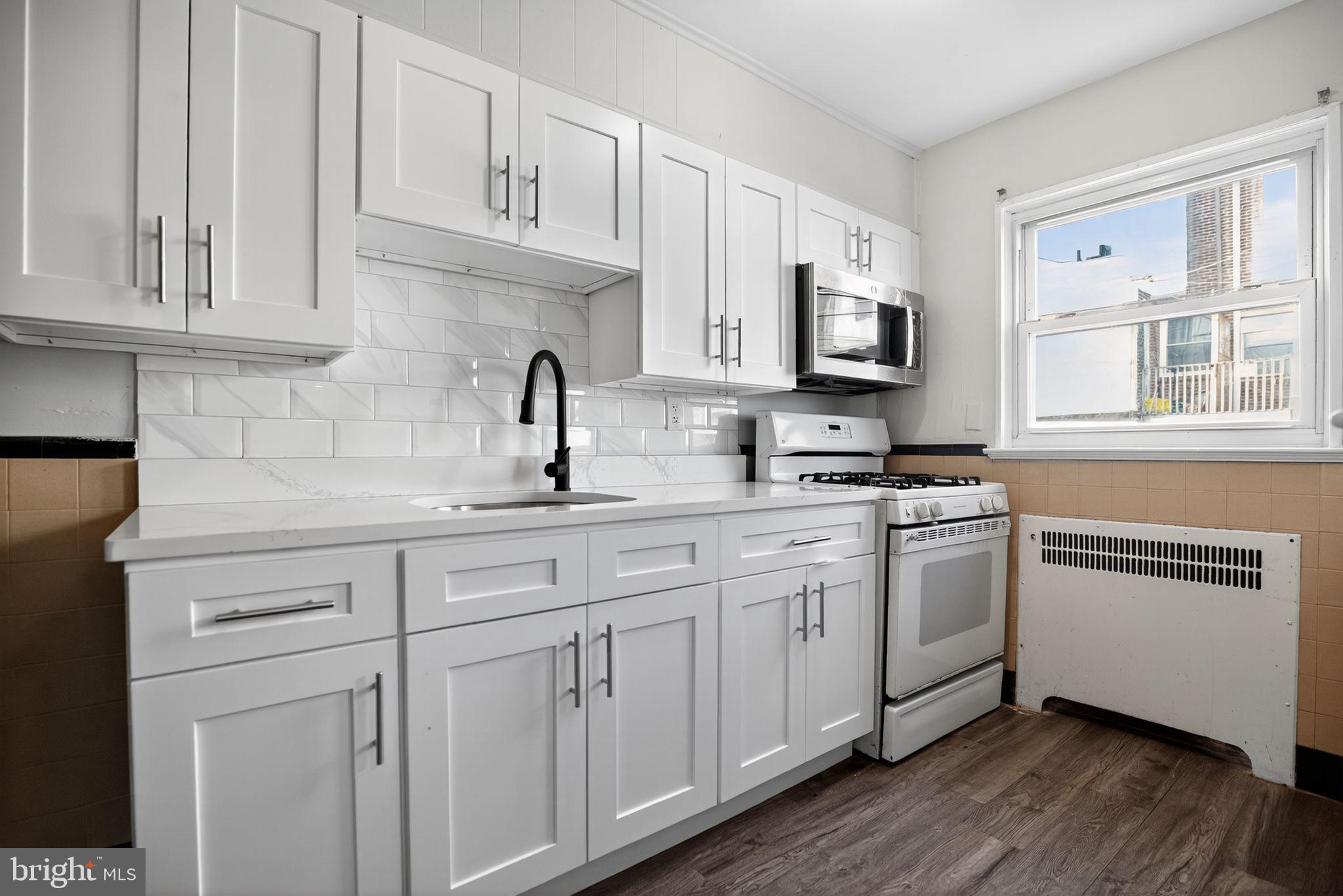558 Snowden Road Upper Darby, PA 19082 - Photo 10 of 30 a kitchen with stainless steel appliances granite countertop a sink a stove a microwave and cabinets