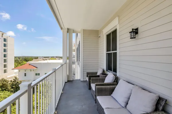 a balcony with furniture and wooden floor