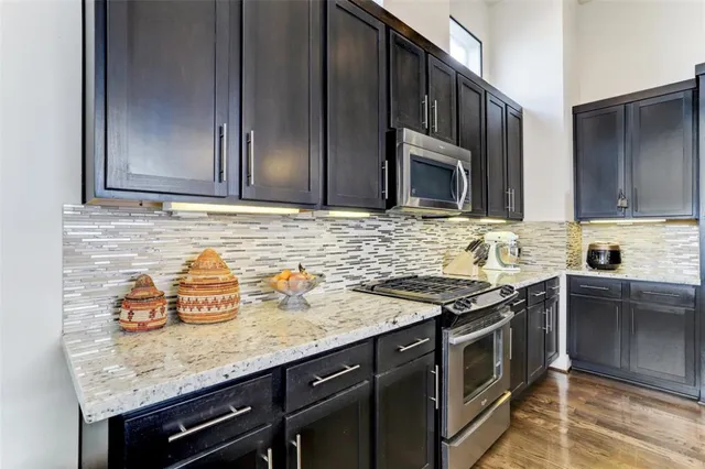 a kitchen with granite countertop cabinets stove top oven and microwave