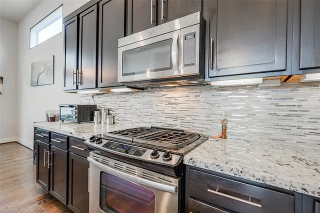 a kitchen with granite countertop a sink stove and cabinets