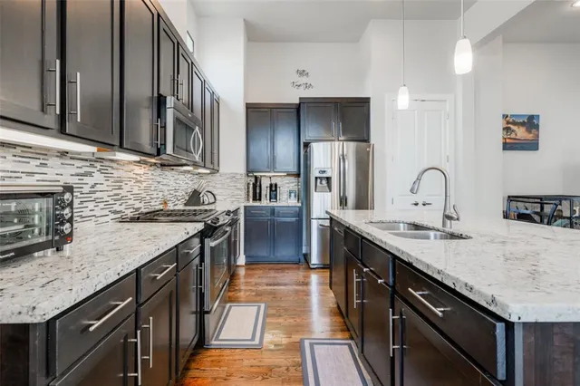 a kitchen with stainless steel appliances granite countertop a stove a sink and a microwave