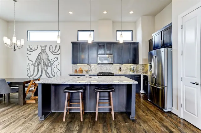 a kitchen with granite countertop kitchen island a counter space and stainless steel appliances