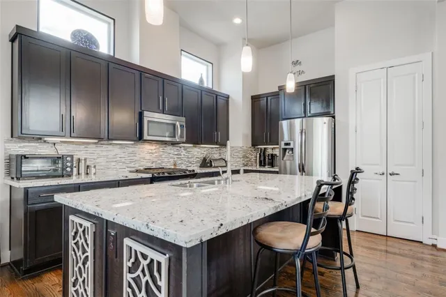 a large kitchen with kitchen island a sink table and chairs
