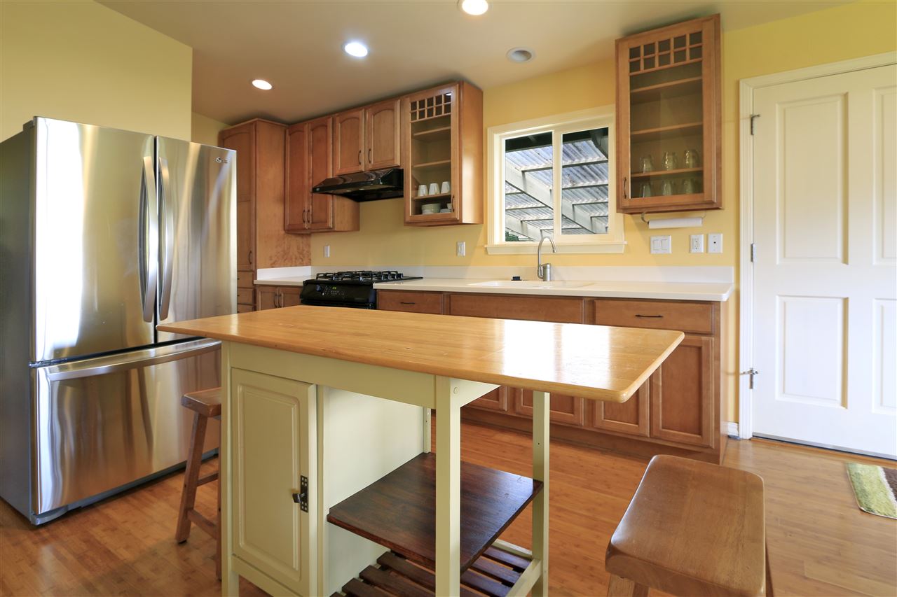 2736 Kaupakalua Road Haiku, HI 96708 - Photo 25 of 30 a kitchen with kitchen island a counter top space cabinets and stainless steel appliances