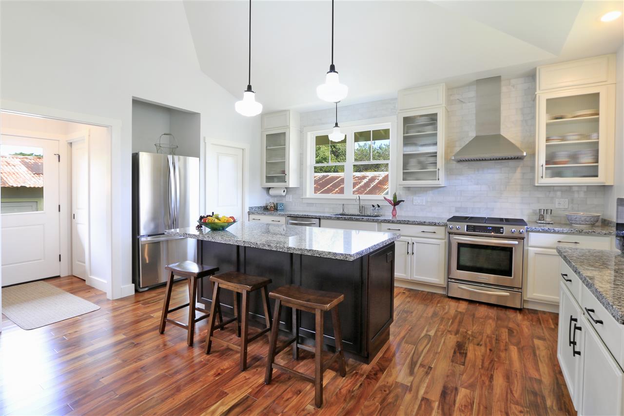 2736 Kaupakalua Road Haiku, HI 96708 - Photo 8 of 30 a kitchen with stainless steel appliances granite countertop wooden floor stove top oven and refrigerator
