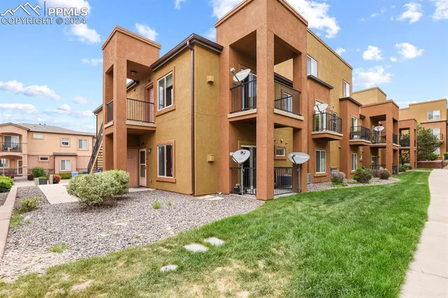 a view of a blue house with a yard and plants