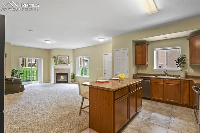 a kitchen with a stove a sink a counter top space and living room view