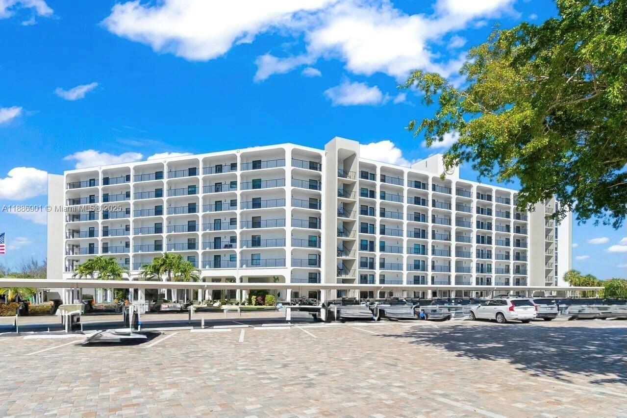 1627 Riverview Road, Unit 212 Deerfield Beach, FL 33441 - Photo 1 of 27 a front view of a building with glass windows and brick walls