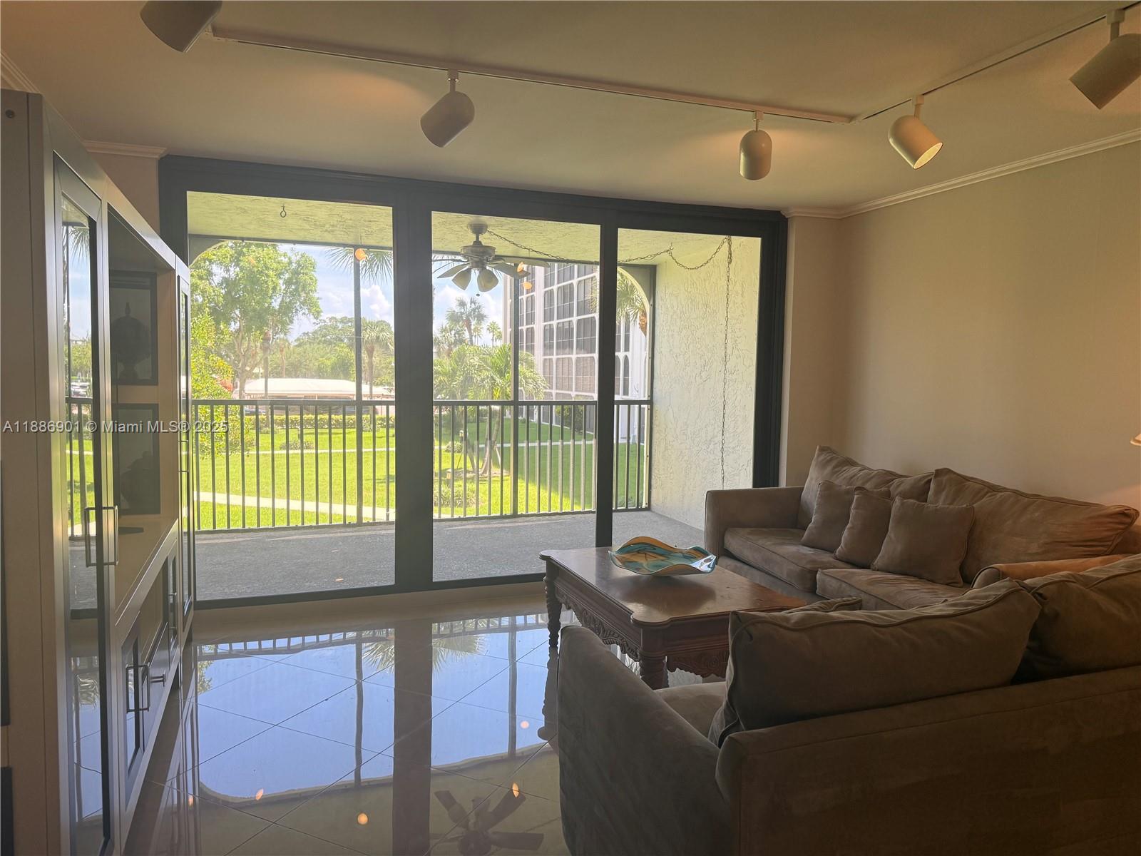 1627 Riverview Road, Unit 212 Deerfield Beach, FL 33441 - Photo 12 of 27 a living room with furniture and a floor to ceiling window