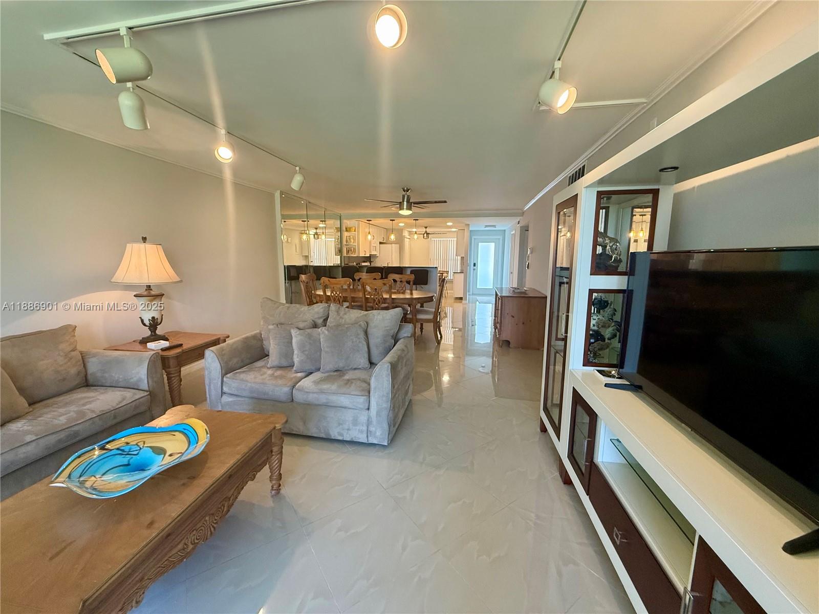 1627 Riverview Road, Unit 212 Deerfield Beach, FL 33441 - Photo 14 of 27 a living room with furniture and a flat screen tv