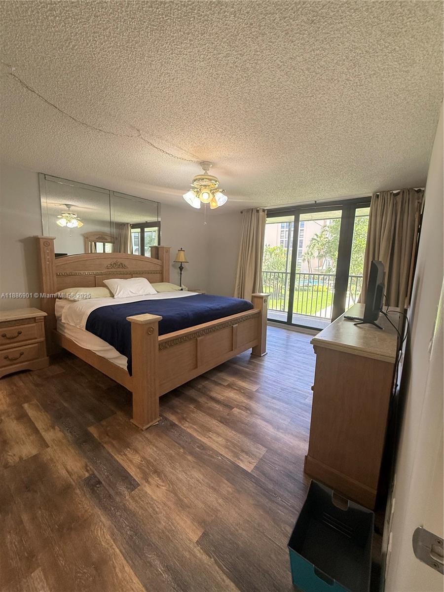 1627 Riverview Road, Unit 212 Deerfield Beach, FL 33441 - Photo 15 of 27 a bedroom with a bed window and wooden floor