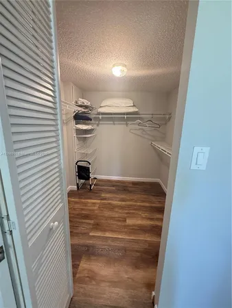 a bedroom with a bed and a flat tv screen on the dresser